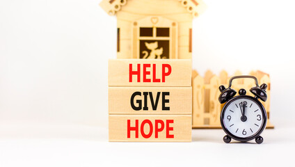 Help give hope symbol. Concept word Help give hope on beautiful wooden block. Black alarm clock. Beautiful white table white background. Business motivational help give hope concept. Copy space.