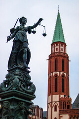 Fototapeta na wymiar Vertical shot of view of the Lady Justice statue and St. Nicholas church in Frankfurt, Germany