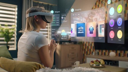 Woman in VR headset chooses clothes in online store chilling at home. 3D futuristic hologram shows widgets in user menu and clothing store website interface. VFX animation. Concept of online shopping.