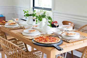 Modern kitchen interior with wicked furniture. Table served with pizza. Pizza party