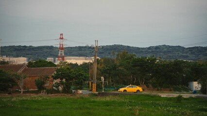 Yellow taxi vehicle parked in a rural area next to buildings