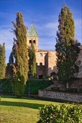 Vertical shot of Puerta de Bisagra old city gates in Toledo against a blue cloudy sky