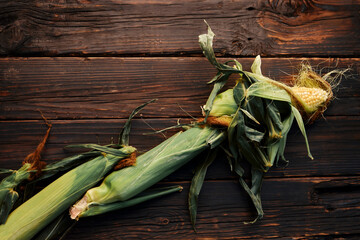 Corn cobs on a wooden background