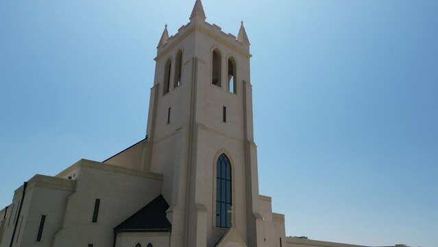 Exterior of St. Philip Apostle Catholic Church with lawns on a sunny day in Flower Mound, Texas