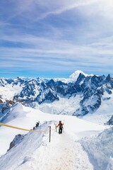 Fototapeta na wymiar Group of skiers holding their making their way down a snow-covered mountain