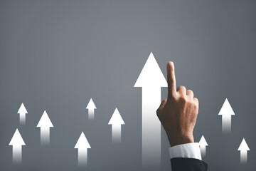 A businessman points an arrow on a graph, portraying the corporate future growth plan. This dynamic...