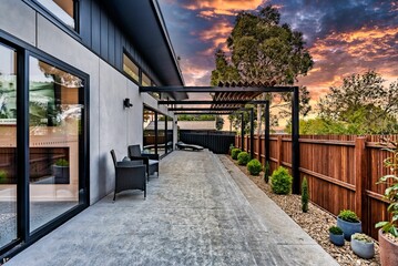 modern home patio area with seating and wood privacy fence at dusk - obrazy, fototapety, plakaty