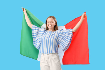 Pretty young woman with flag of Italy on light blue background