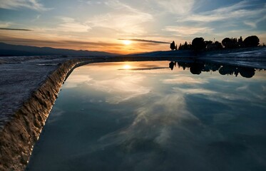 Sunset reflecting on the tranquil waters of a lake in Pamukkale Natural Park, Turkey