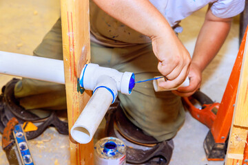 Plumber glues pvc plastic drainage pipes system new house construction - obrazy, fototapety, plakaty