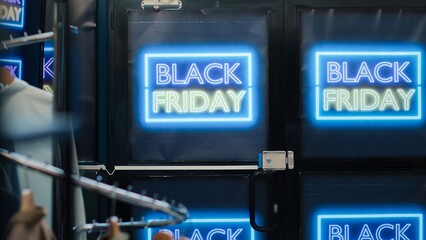 Fototapeta premium Front door of clothing shop open on black friday promotions day, special offers for merchandise and discounted items. Signs and banners showing big sales in retail store boutique.