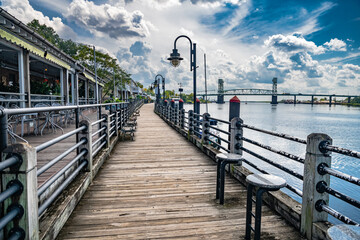 Naklejka premium Riverwalk along the waterfront of the Cape Fear River overlooking Memorial Bridge Wilmington, NC