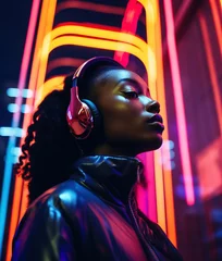 Poster Fashionable young black woman listening to music with headphones on night city street with neon lights. © Lina