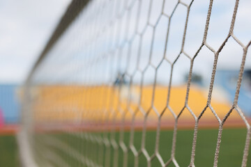 Close-up of soccer goal net in stadium against blue and yellow fan zone © KIFOR PRODUCTION