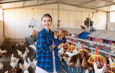 Portrait of positive highly experienced european adult woman working in chicken farm