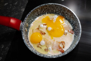 Scrambled eggs with bacon in a pan