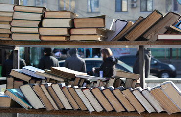 Street photo. Selling old antique books at a street market. Personal items at a flea market. Concept for sale, reading, learning, education, bookstore, history, fairy tale, literature. City bookshelf