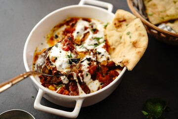 Afghani Doi Begun - Eggplant prepared in tomato sauce topped with seasoned yogurt _ Baigan masala served with Roti