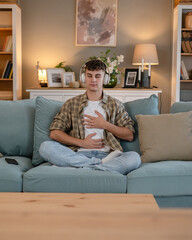 One teen man doing guided meditation yoga self care practice at home