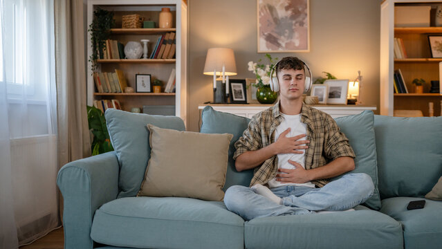 One teen man doing guided meditation yoga self care practice at home