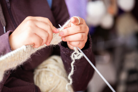 Closeup of the hands of a woman weaving a traditional ruana from the town of Nobsa in the department of Boyaca in Colombia