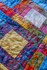 Detail of colorful quilt made in block pattern.