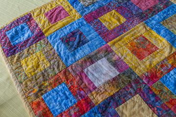 Hand-quilted batik fabric table runner quilt.