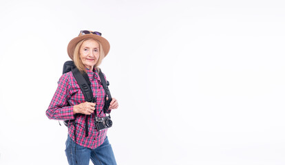 Healthy active cool elderly woman casual jeans with backpack hat standing over isolated white background. Cheerful retired female sunglasses on hat hold camera carefree vacation adventure holiday.