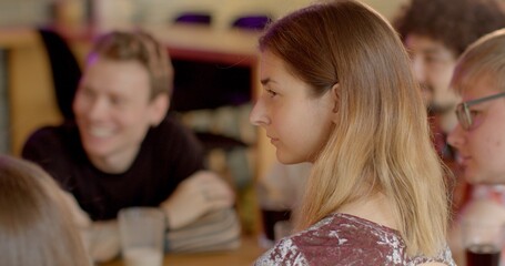 Lifestyle portrait of pensive girl analyzing what she heard at meeting. Young people gathering in club indoors. Students exchange ideas, collectively analyze problems, brainstorm strategies listening 