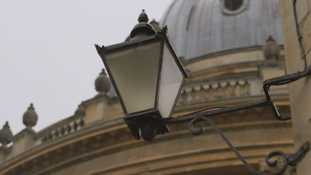 Heavy rain drops on rainy day with typical english vintage lamp and Oxford university building background.Bad english weather concept