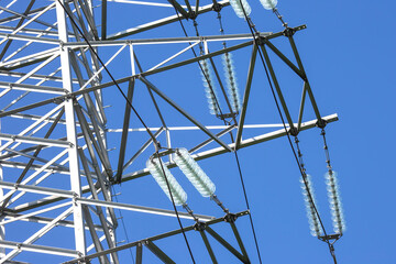 High voltage tower with electrical voltage wires isolates close-up against the background of...