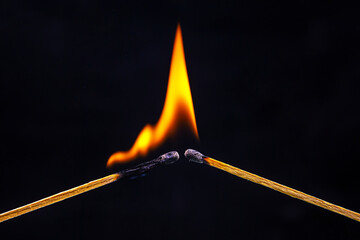 Burning match on a black background. Heat and light from fire flame