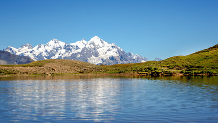 the Caucasus mountain range in the reflection of the mountain lake