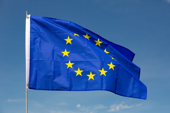 Big flag of European Union fastened on stick against background of blue sky under daylight