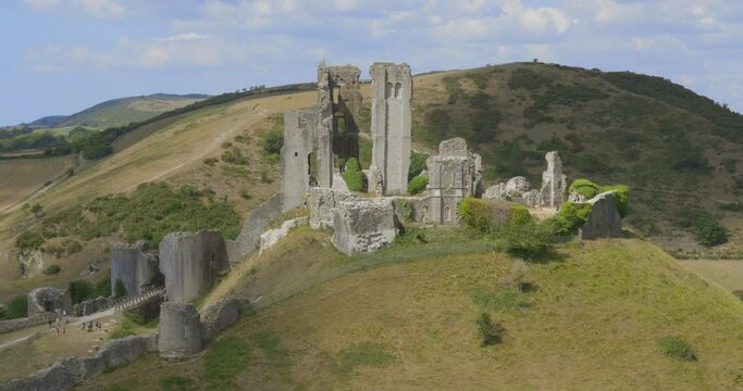Aerial close up view Corfe Castle Ruins Medieval heritage in Dorset England UK Township. Tourist explore Corfe castle ruins on hilltop