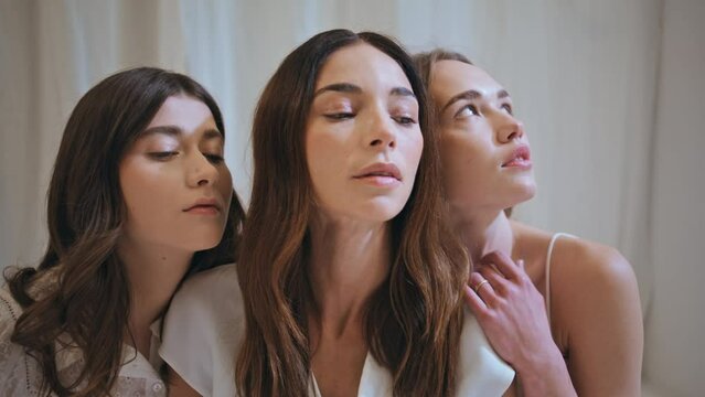 Supportive women embracing together closeup. Hopeful models look camera believe