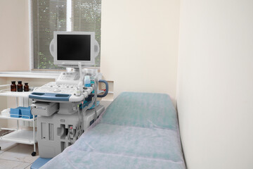 Ultrasound machine, medical trolley and examination table in hospital. Space for text