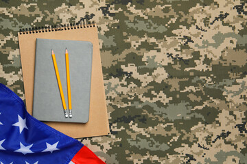 Notebooks, pencils and flag of United States on camouflage background, flat lay with space for...