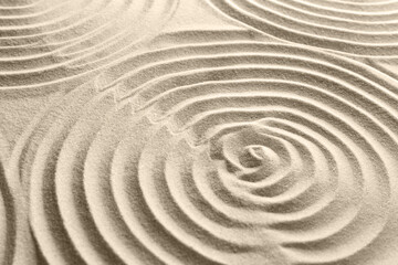 Fototapeta na wymiar Beautiful patterns on sand, closeup. Zen garden