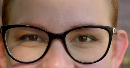 Close-up smiling woman eyes in glasses to correct or enhance vision, sense of connection, powerful symbol of a person's identity. Recognizable features of an individual. Girl wearing spectacles close