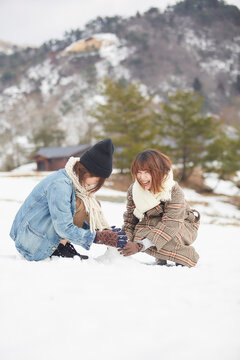 雪の積もった広場で遊ぶ二人の女性