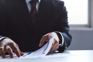 資料を見ているスーツを着た男性