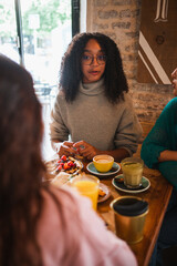 Mixed race young woman with her friends in a coffee shop. They are having a break from university