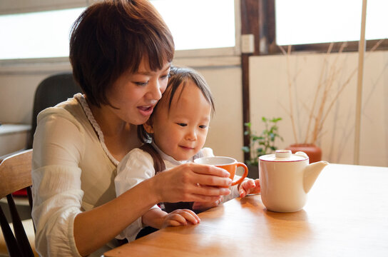 テーブルでお茶を飲んでいる親子