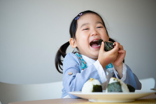 おにりぎを食べながら笑っている女の子