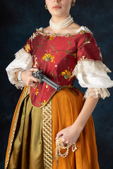 Woman wearing a Renaissance, Tudor, Georgian, or high fantasy costume with a red embroidered bodice...