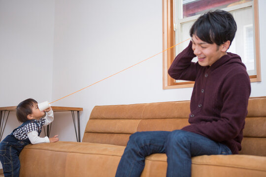 糸電話をする男の子と父親