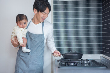 キッチンで子供を抱っこする父親