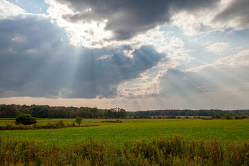 Wisconsin farmland with sunrays coming out of the clouds in September - Powered by Adobe