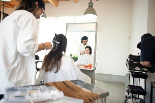美容師にヘアセットをしてもらう女性